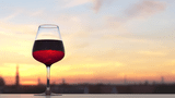 Ein Glas Rotwein bei Sonnenuntergang